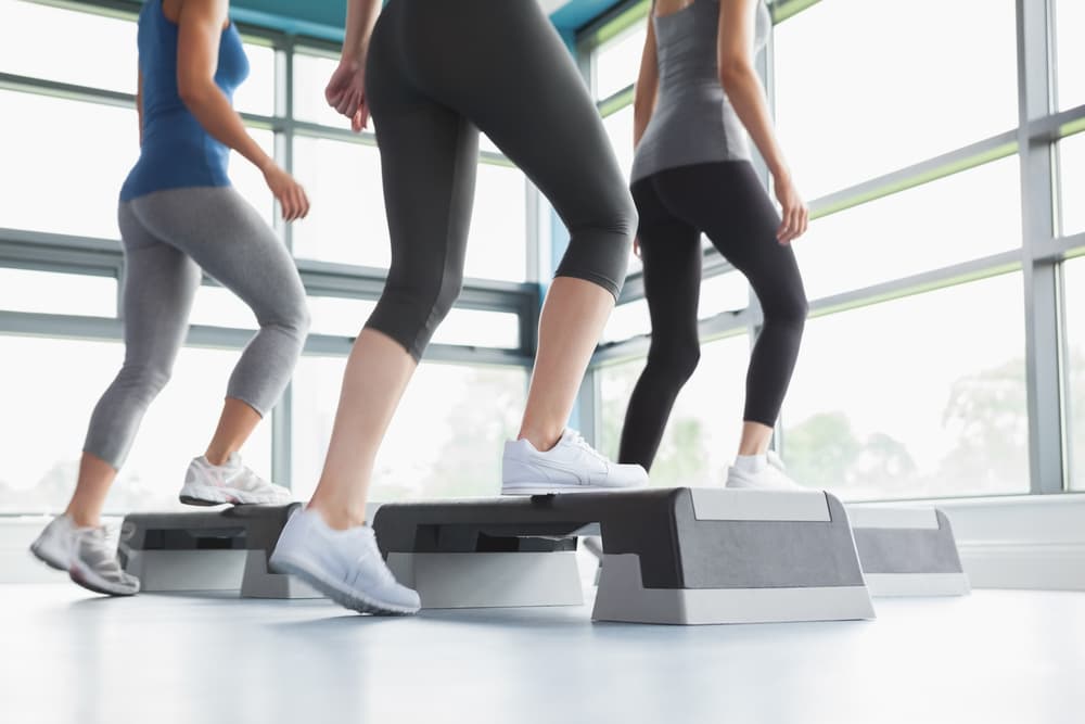 Three young woman doing step up exercises