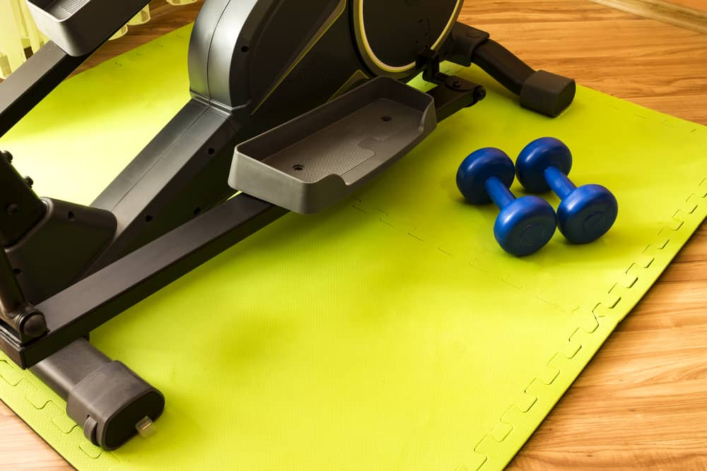 Elliptical and dumbbells on rubber mat