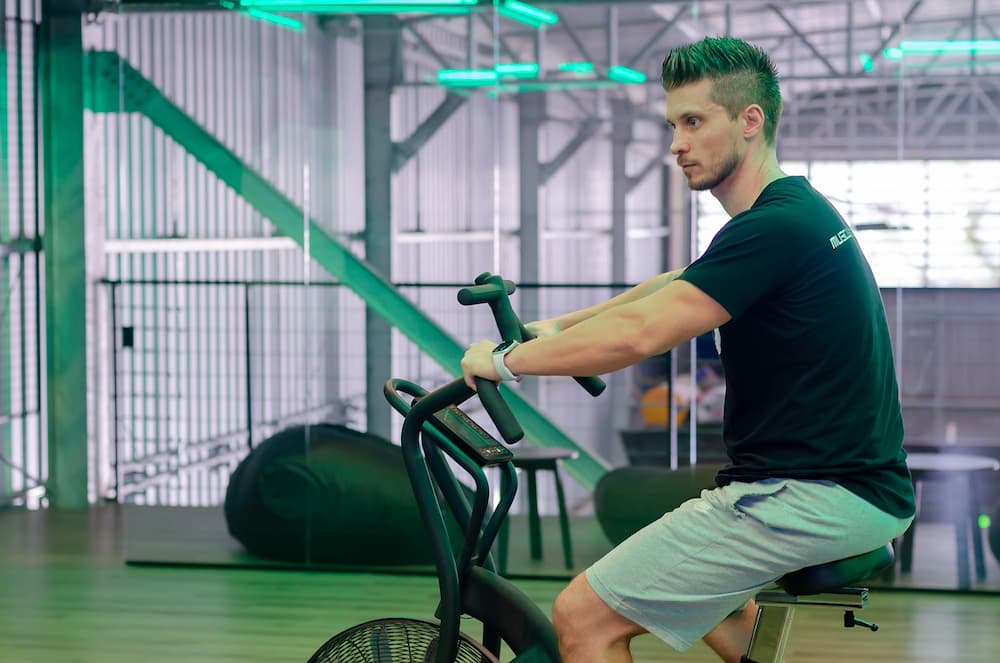 man cycling on upright exercise bike