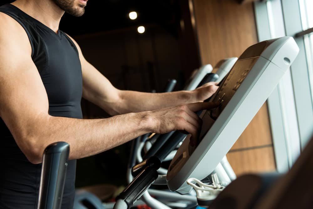 Man Adjusting the Exercise Bike for a More Challenging Workout