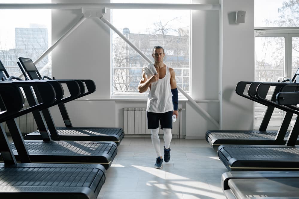 Man in a Gym with Manual and Motorised Treadmills