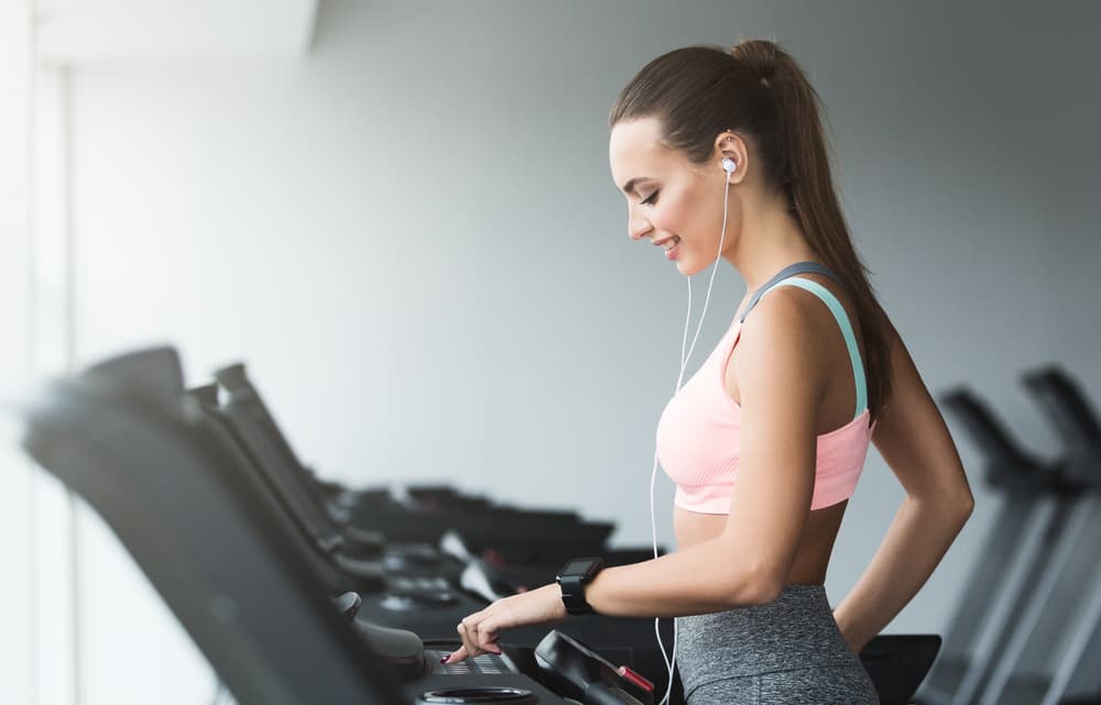 Woman Adjusting the Treadmill Speed